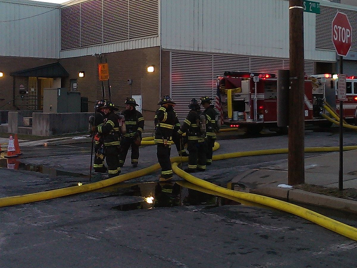 Group of Firefighters Moving Hoses